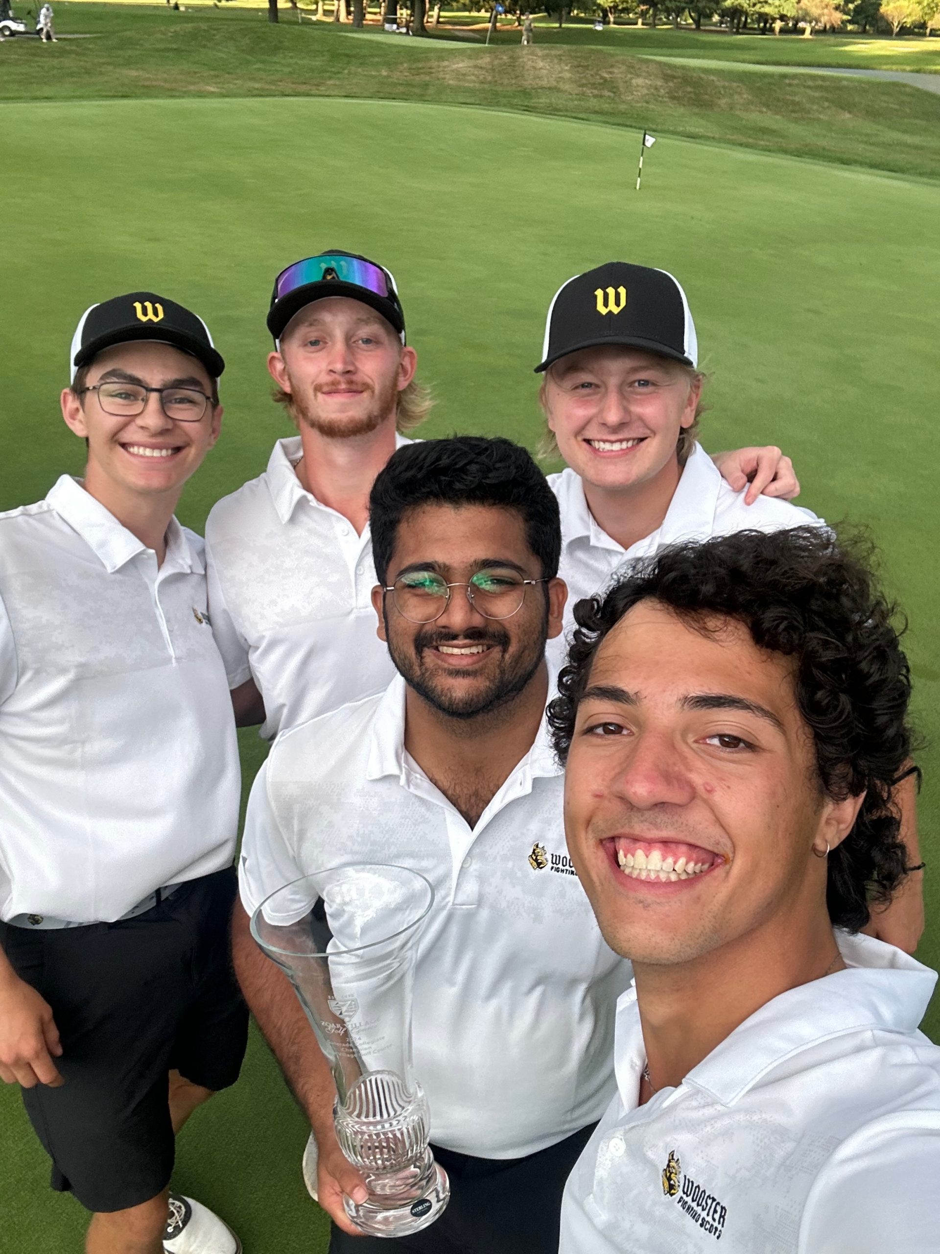 Pictured: Wooster Men's Golf Team taking a selfie with the trophy